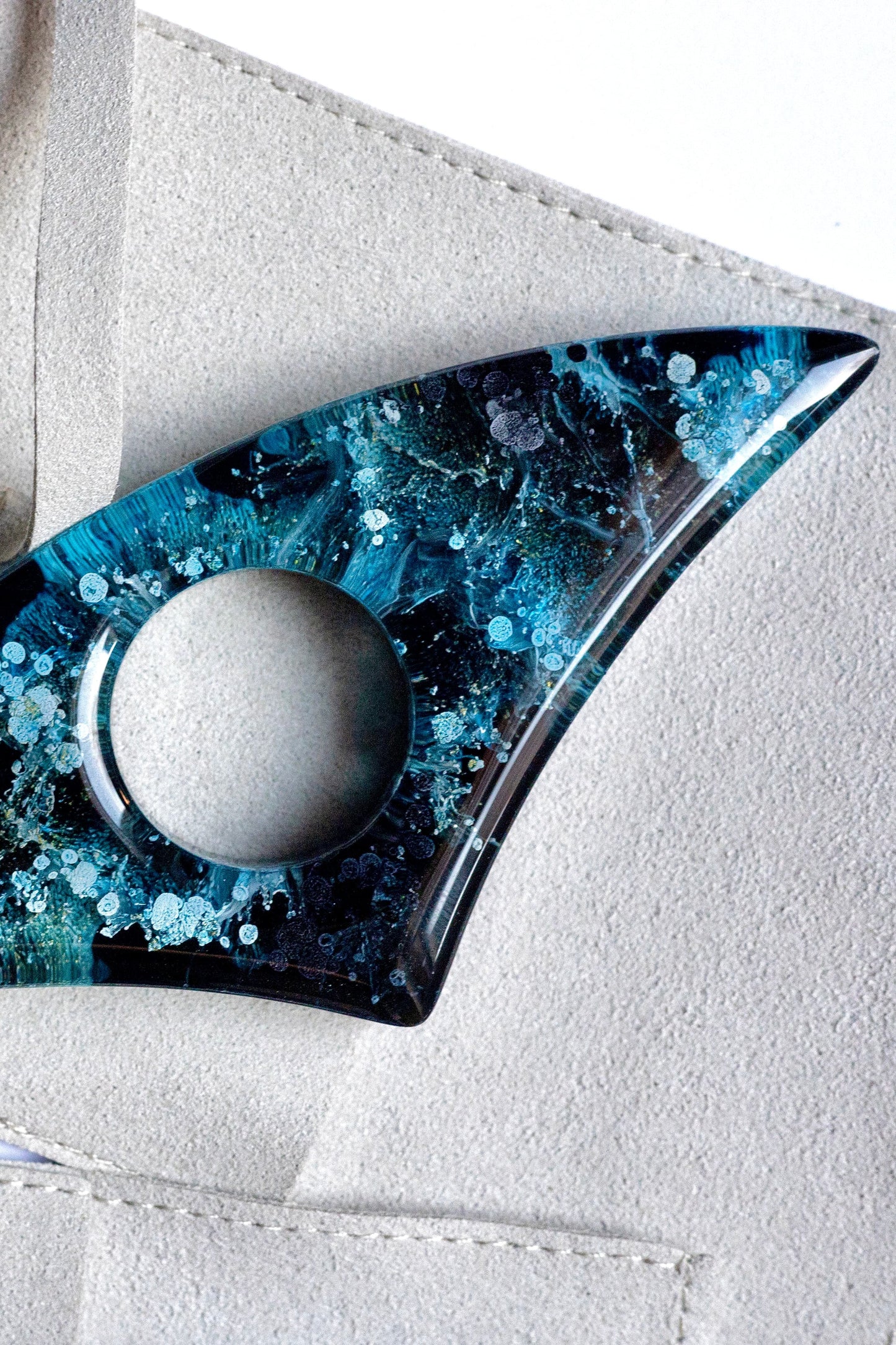 Handmade page holder with blue and black design on a white background