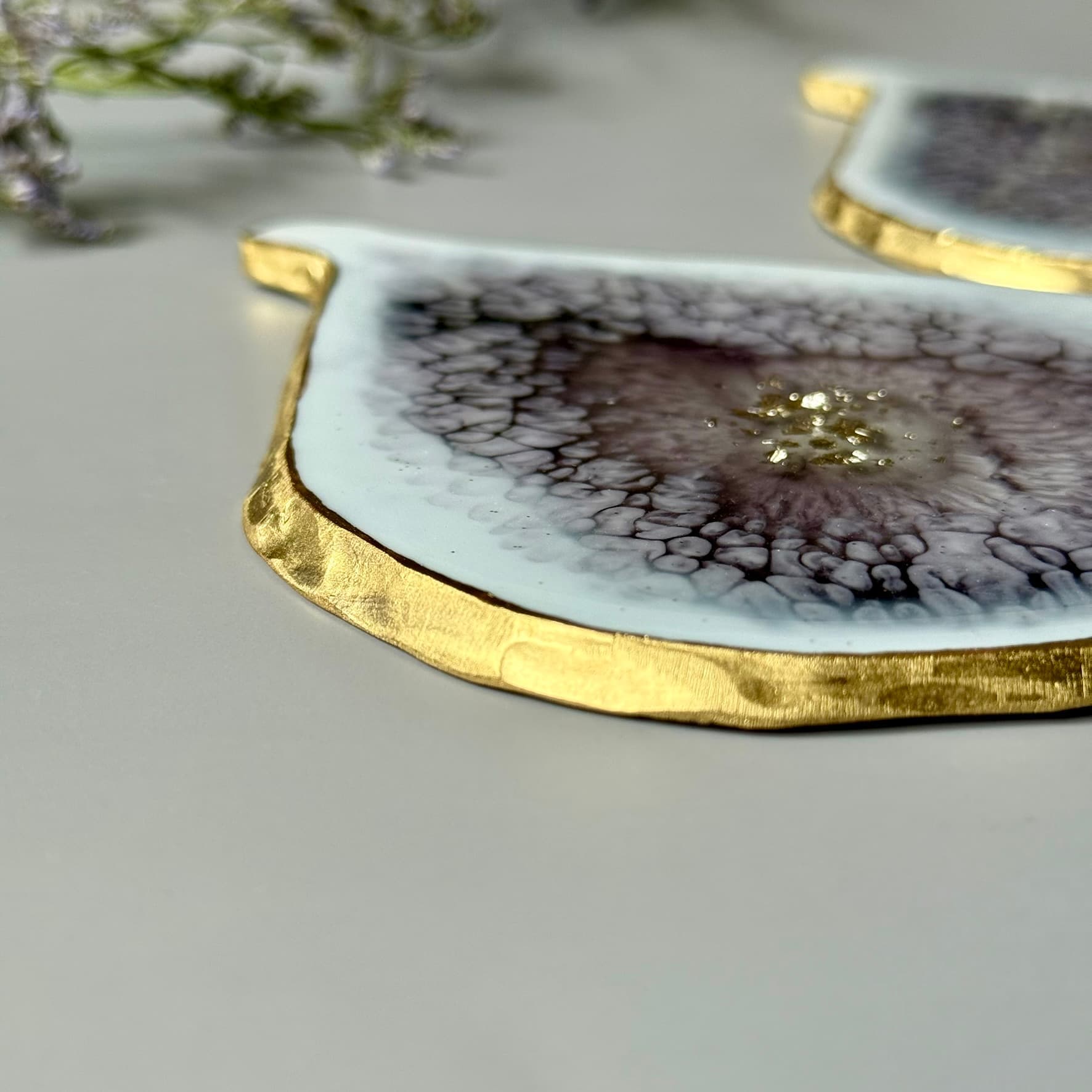 Decorative coaster with gold edge and intricate design on a light gray background