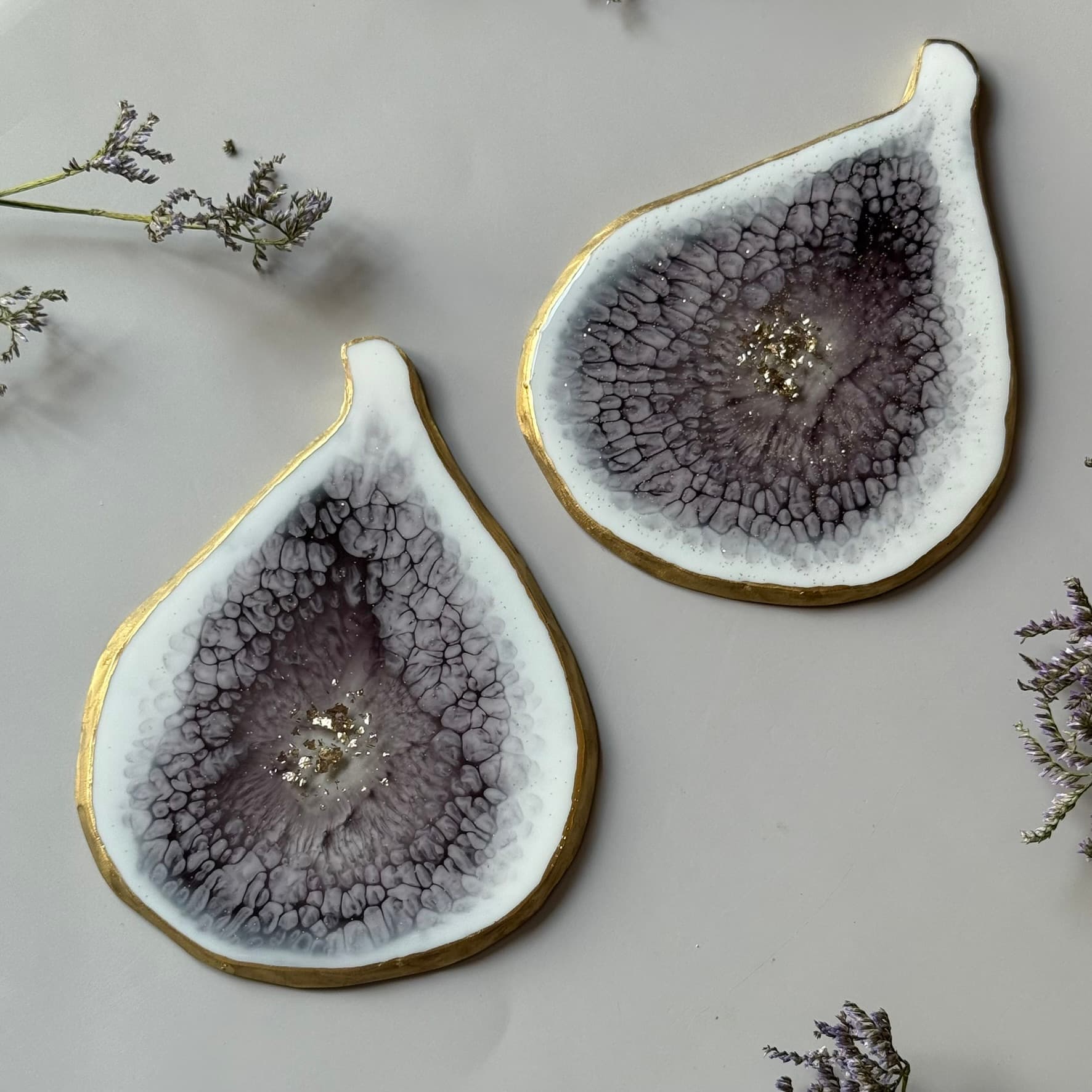 Two resin coasters with a unique texture and gold rim on a light background.