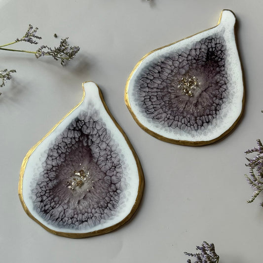 Two resin coasters with a unique texture and gold rim on a light background.