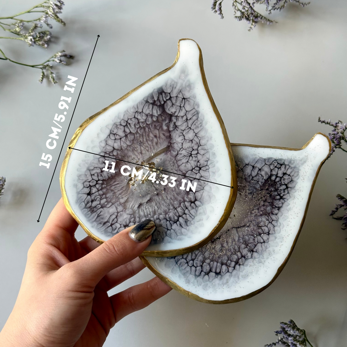 Handmade fig-shaped plate held by a hand with measurements on a light background