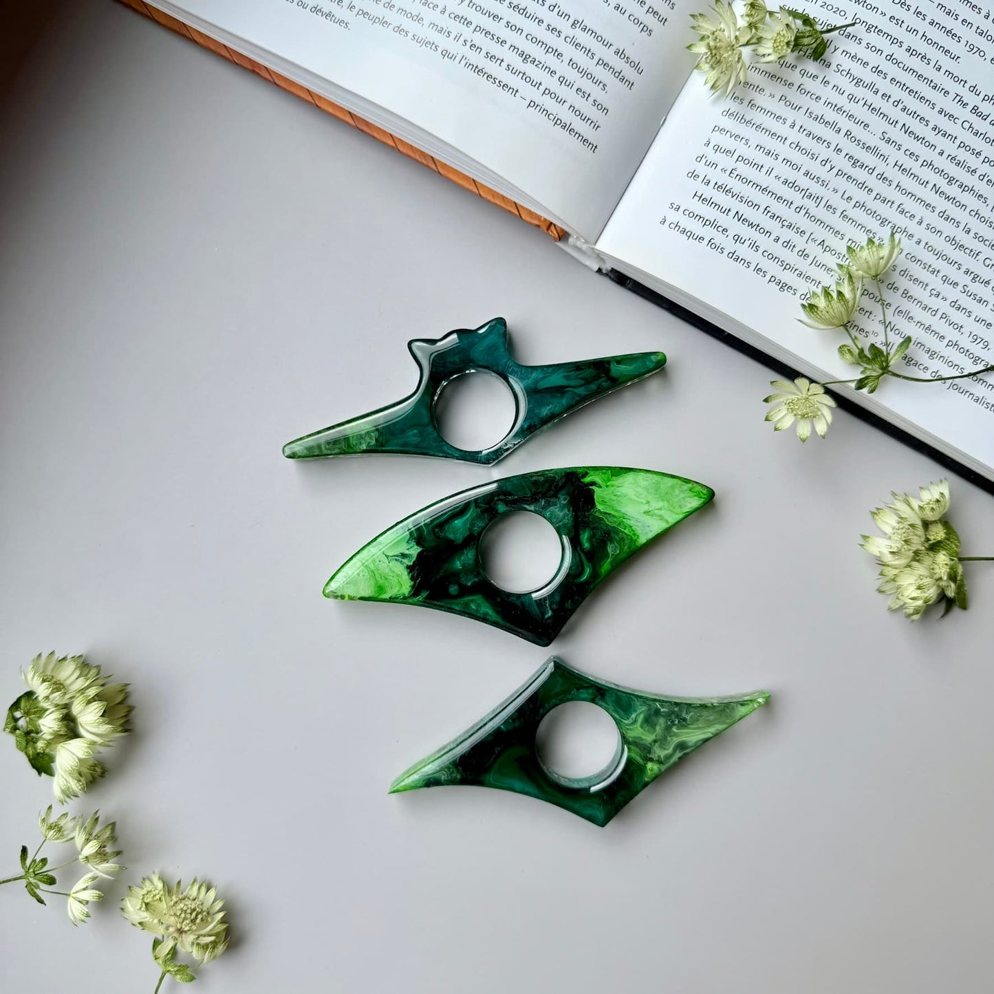 Handmade green resin page holders styled with an open book and dried white flowers, perfect for book lovers.