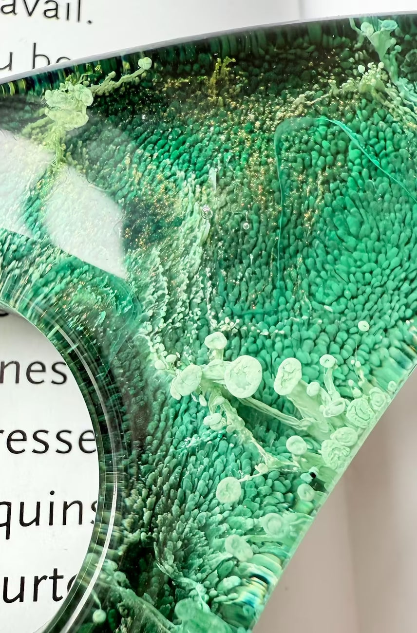Extreme close-up of petri effect in handmade green resin, showing cell-like textures and artistic swirl detail.