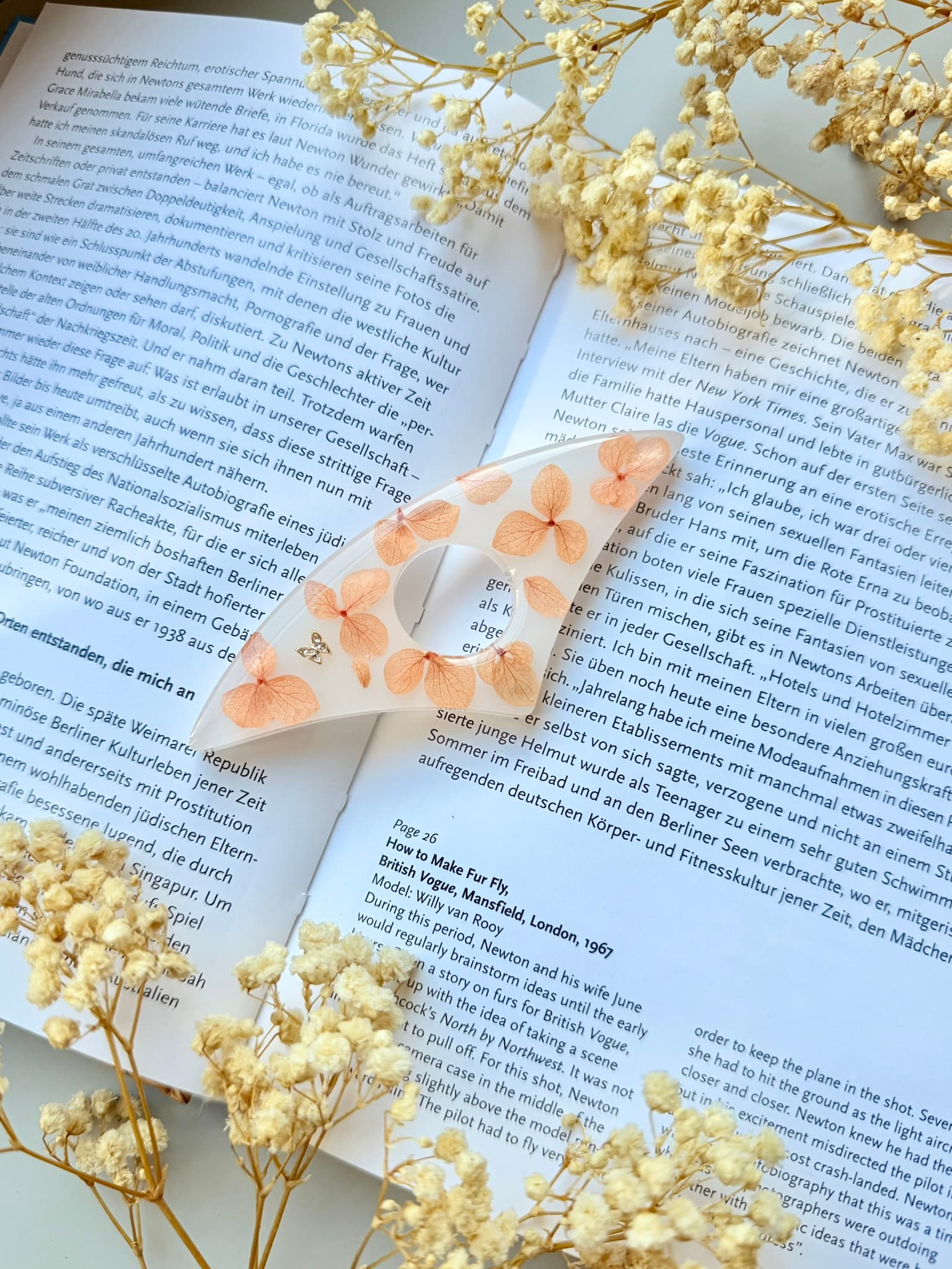 Handmade page holder on an open book with dried flowers around