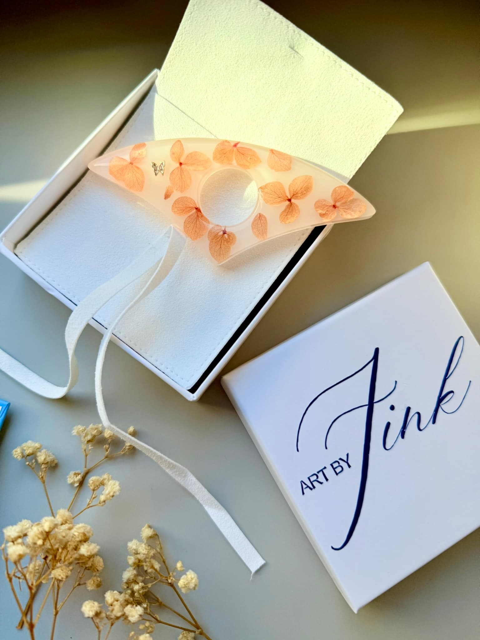 Handmade Page Holder with real flowers on a white box labeled 'Art by Fink' on a light background.