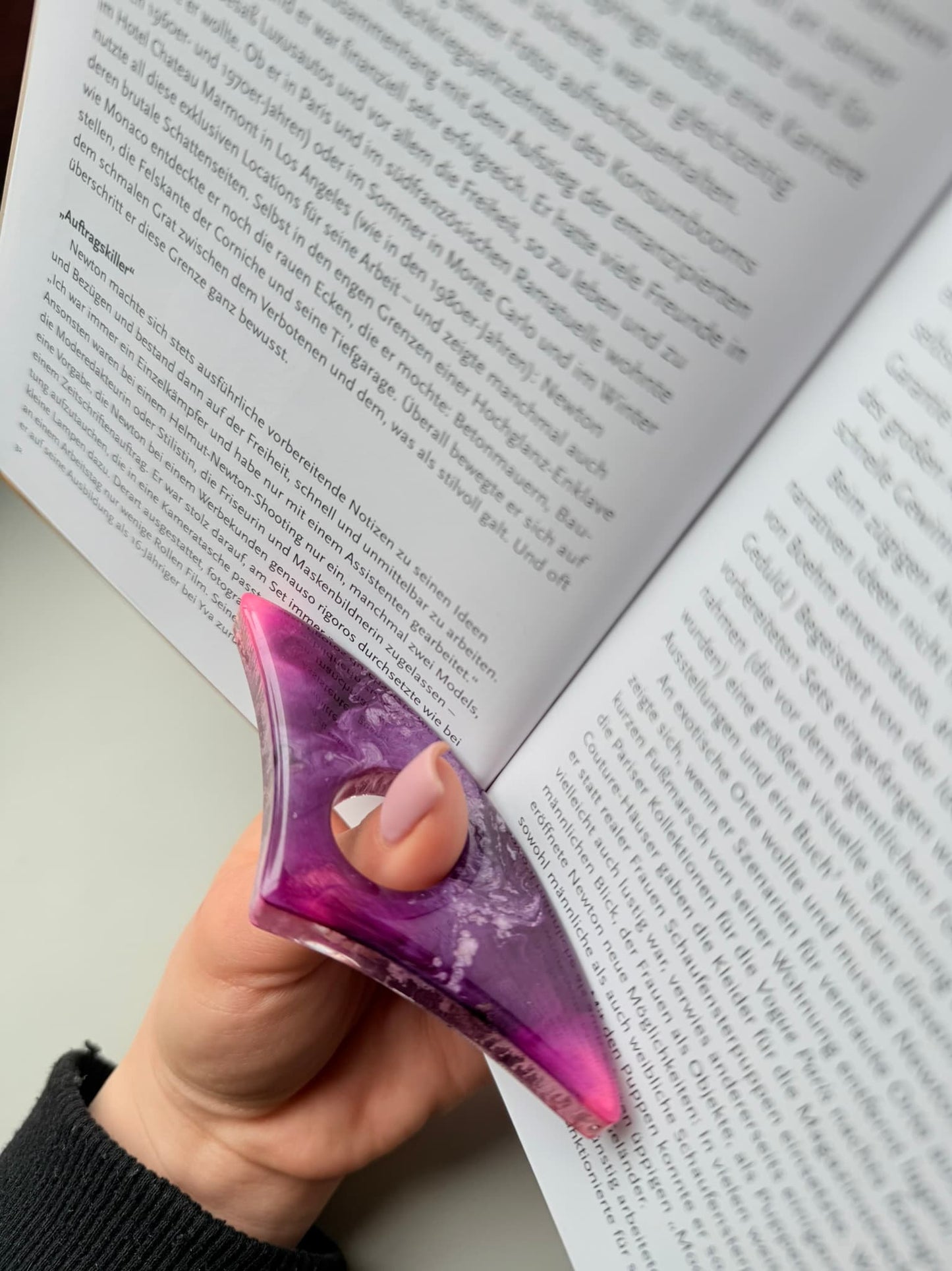 Purple handmade page holder held over an open book