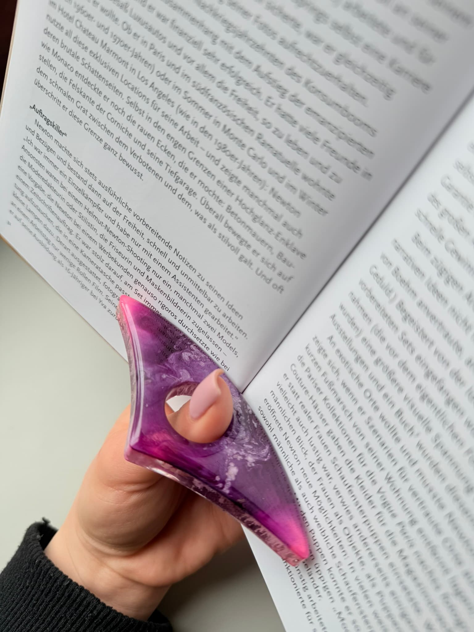 Purple handmade page holder held over an open book