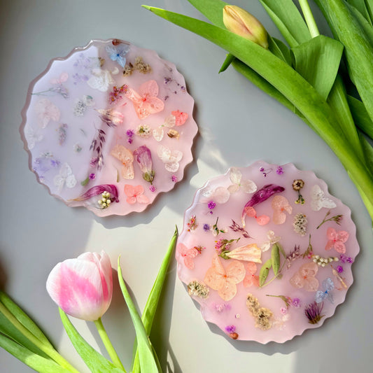 Two decorative plates or coasters with floral designs on a light gray background with tulips.